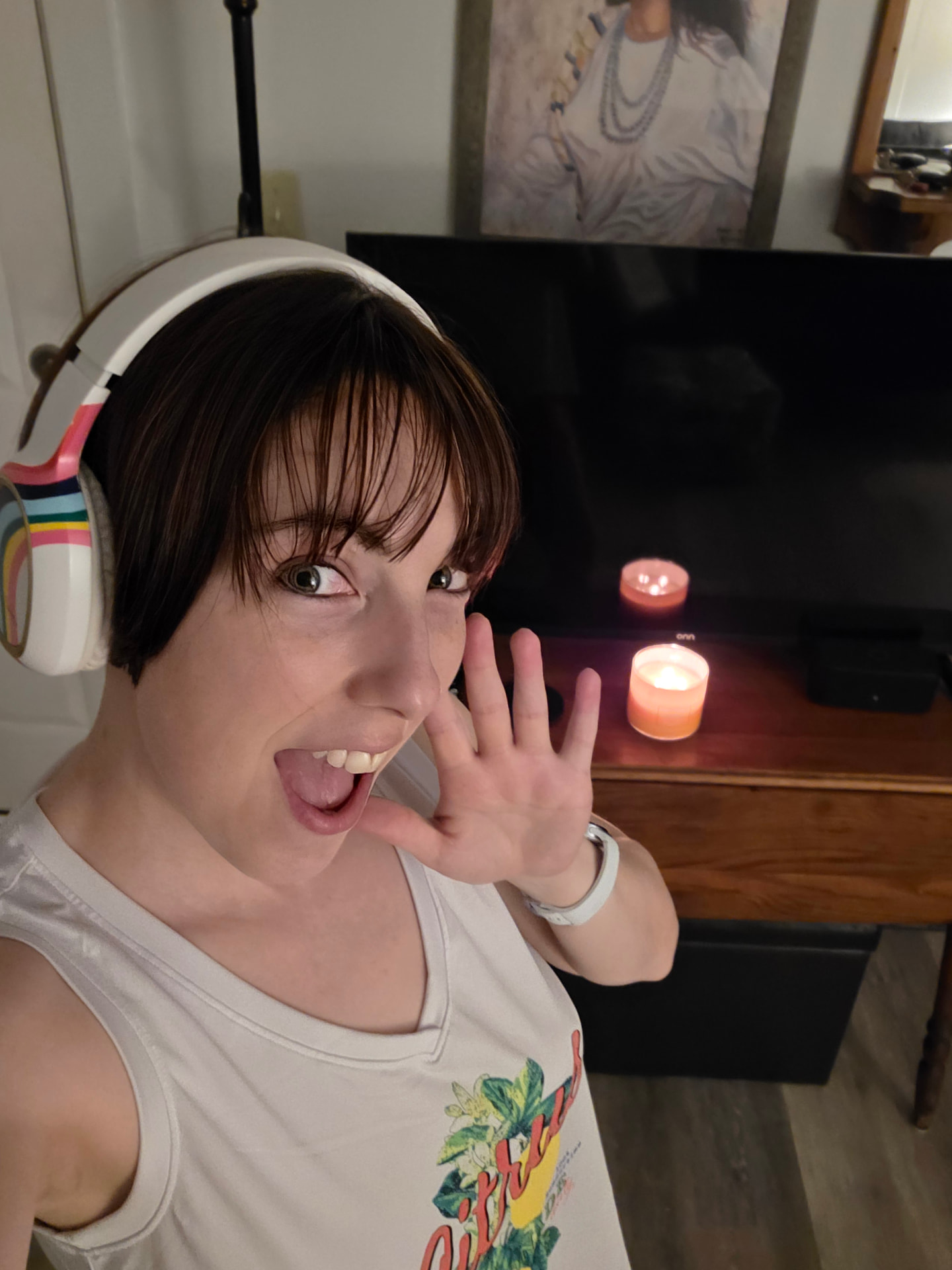 Abi in headphones making a goofy face by candlelight
